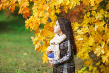 adorable little girl with autumn leaves in the beauty park