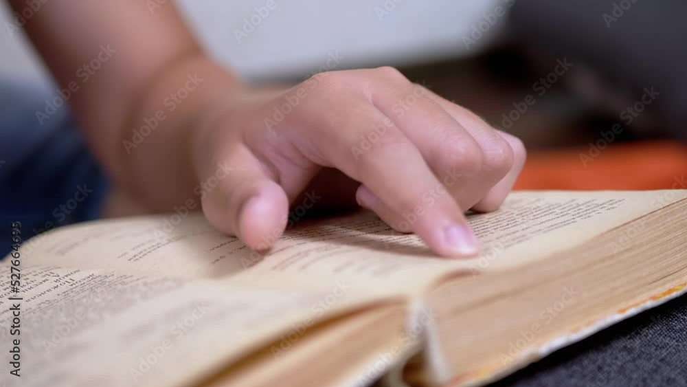Poster child runs finger along page of book and reads quickly. reading remotely at home. self-isolation. on
