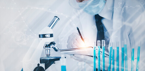biochemical research scientist working with a microscope for the virus,Doctor man write a history of the experimental results in a , laboratory glassware containing chemical liquid for design.