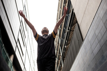 Portrait of a male dancer performing an urban modern dance with some buildings behind in London.
