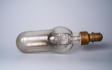 Vintage glass light bulb on isolated gray background. Retro incandescent lamp with tungsten...