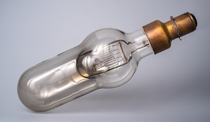 Vintage glass light bulb on isolated gray background. Retro incandescent lamp with tungsten...