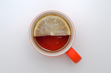 mug of tea with lemon slice on white background top view