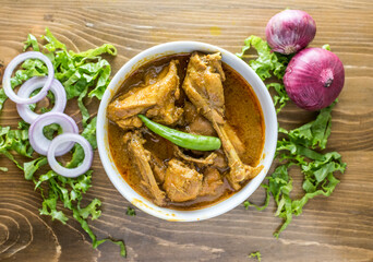 Desi Chicken Rezala with onion, pepper and salad served in a dish isolated on wooden table top view of indian and bangladesh food - obrazy, fototapety, plakaty