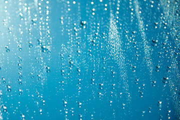 Naklejka na ściany i meble Drops on the glass are blue. Background.