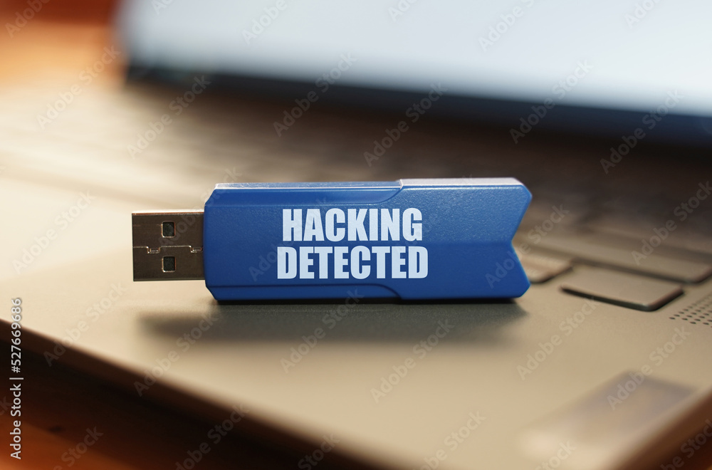 Poster on the laptop keyboard is a flash drive with the inscription - hacking detected