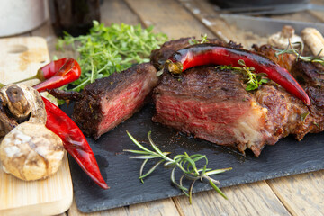 Grilled beef steak on wooden table top. Healthy food concept. Beef cut outdoors, garden kitchen, bbq grill patio