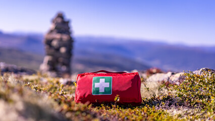 First aid kit in red case is ready for big hiking trip in mountains