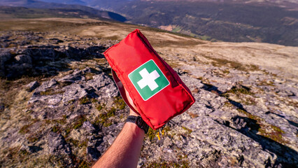 First aid kit in red case is ready for big hiking trip in mountains