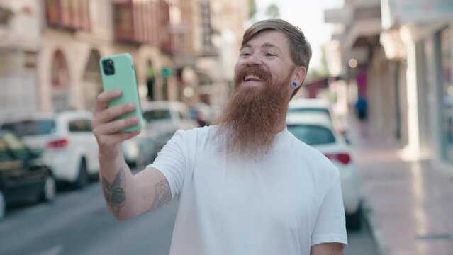 Young redhead man smiling confident having video call at street