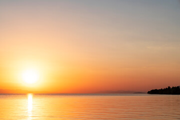 Naklejka na ściany i meble Beautiful golden sunset over the lake. Sunset landscape.