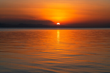 Naklejka na ściany i meble Beautiful golden sunset over the lake. Sunset landscape.