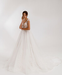 Full-length portrait of beautiful girl in wedding long stylish puffy dress with lace and posing...