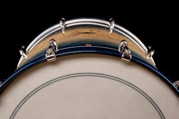 part of beautiful bass drum on a black background with reflection, for advertising and inscription