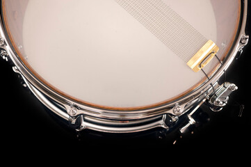 part of a snare drum with a string on a black background with reflection, for advertising and inscriptions