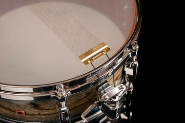 part of a snare drum with a string on a black background with reflection, for advertising and inscriptions