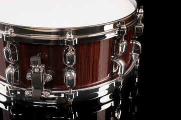 part of a snare drum on a black background with reflection, for advertising and inscriptions