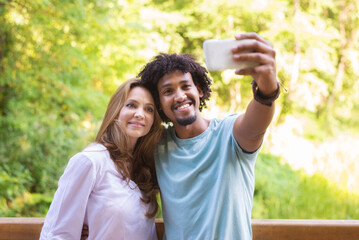 Young mixed race couple taking selfie in the summer nature