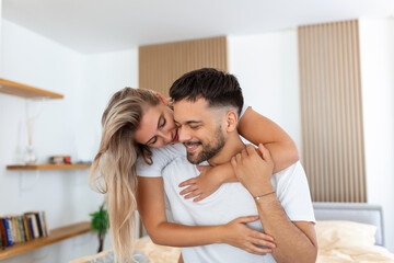 Young beautiful couple is lying in the bed at morning. Portrait of a relaxed young couple lying in bed at home. Beauty portrait.