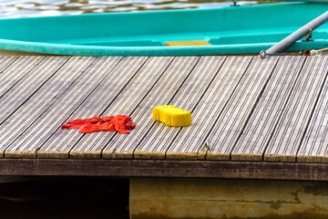 Sponge and rag lie on a wooden pier near boats