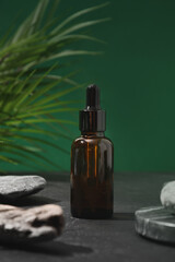 Moisturizer essence oil for face and body care decorated green leavs in shadow on green background....