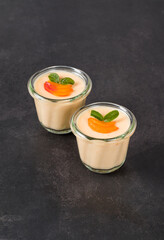 Cream apricot pudding, Panna Cotta in a glass. Dark gray background	