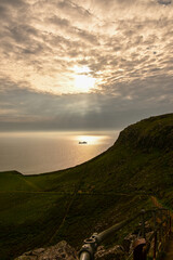 Fototapeta premium Schiff fährt übers Meer bei dramatischem Sonnenuntergang am Neist Point, Isle of Skye, Schottland