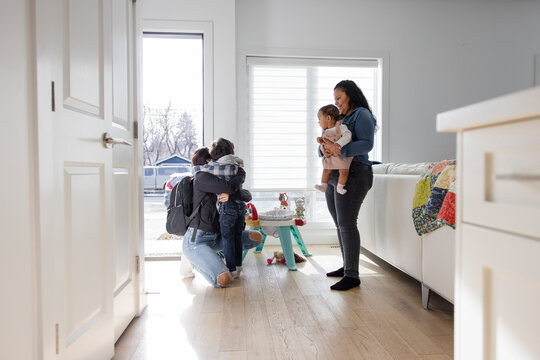 Son Hugging Mother Goodbye At Front Door