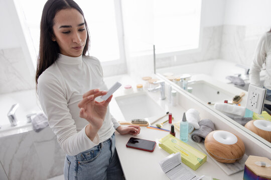 Young Woman Taking Covid Rapid Antigen Test In Bathroom