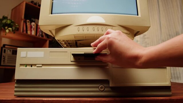 Using diskette for old computer. Music recorder, playing retro computer games. Vintage device for office, obsolete technology. 