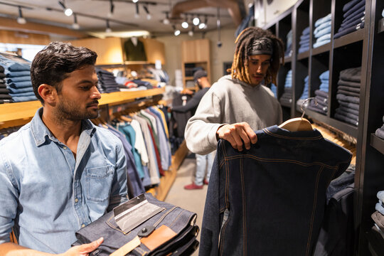 Men shopping for denim in clothing store