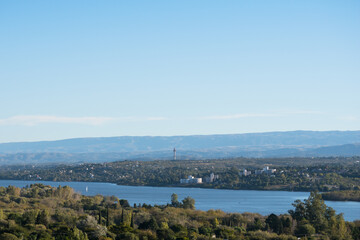Fototapeta na wymiar Vista panoramica del lago San Roque en la provincia de Cordoba, Argentina, con las sierras chicas de fondo y cielo azul en el atardecer