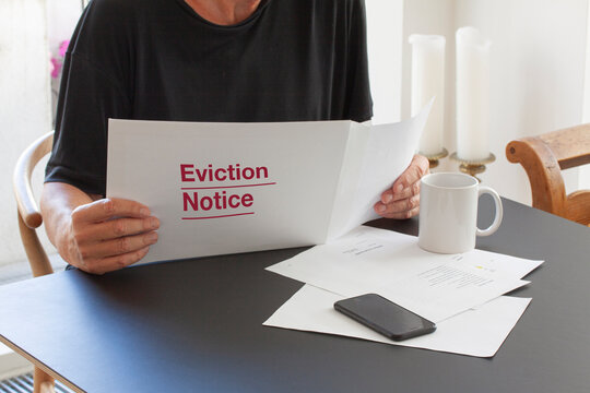 Man looking at Eviction Note. Frustrated about mortgage payment and financial debt. Being evicted from his home, Close up image.