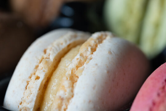 Close-up of flavourful yellow macaron on blurry background. Sweet concept. Excellent image for dessert banners and advertisements.