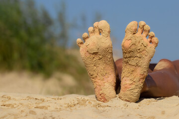 Female tanned feet in the sand. Vacation, travel and freedom concept. People relaxing in summer.