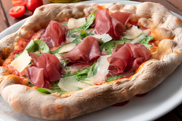 Deliziosa pizza con breasola, scaglie di grana, rucola e sugo, cibo italiano 