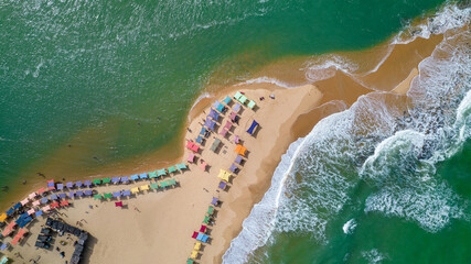 Aerial view of Caraiva beach, Porto Seguro, Bahia, Brazil. Colorful beach tents, sea and river