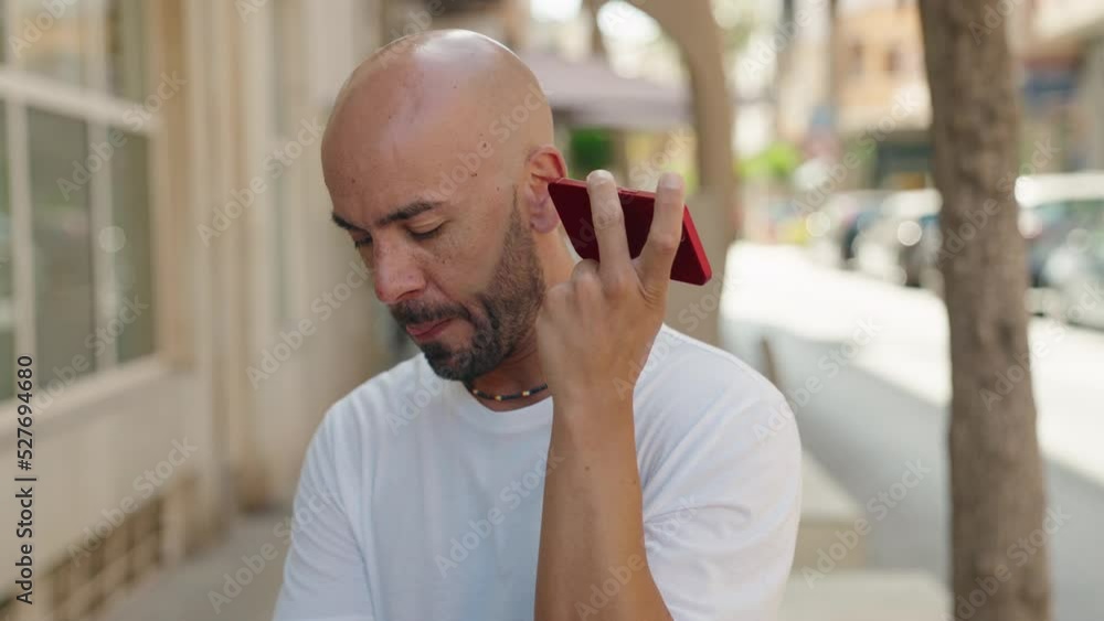 Sticker young bald man smiling confident listening audio message by the smartphone at street