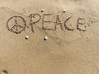 on the beach is carved with letters in the smooth sand the writing Peace