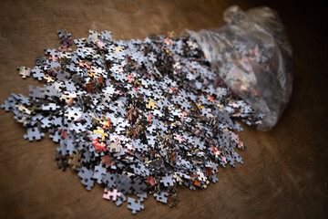 There are a lot of details from the paper puzzle on the table.Pour out the old puzzle.Solving many...