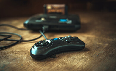 A game TV set-top box from the 90s on the table. Dusty 16-bit console.Old school.A joystick for...