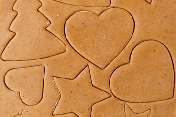 Making cookies in the shape of heart, Christmas tree, star from shortbread dough.