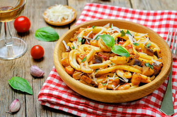 Eggplant tomato basil pasta in a plate on a wood backround