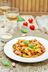 Eggplant tomato basil pasta in a plate on a wood backround