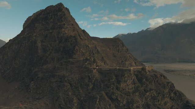 4K AERIAL, drone orbits around the ruins of an old stone fort in the Himalayas, shot during sunrise (golden hour). Kharphocho fort, Skardu, Gilgit Baltistan, Pakistan 