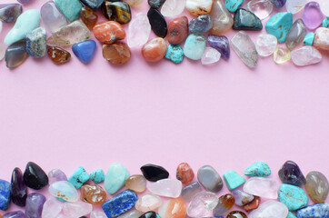 Frame in the shape of a wave of semi-precious minerals on a pink background. Healing crystals. Copy...