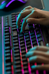 Manos en teclado moderno luminoso de colores