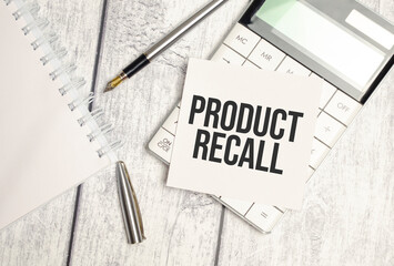 PRODUCT RECALL word on white paper card and calculator