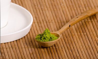 Matcha tea powder in wooden spoon