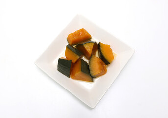 白い皿にもりつけたカボチャの煮物